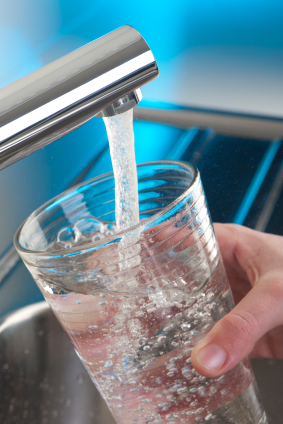 Arlington Water Softener Installation Glass being filled with clean water from a modern faucet, illustrating the benefits of water softening for improved home water quality.