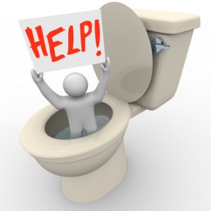 Person in toilet holding "HELP!" sign, symbolizing urgent plumbing issue needing immediate assistance, relevant to emergency plumbing services in Falls Church, VA.