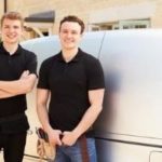 Two professional plumbers standing confidently in front of a service van, showcasing expertise in commercial plumbing services.