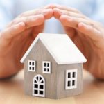 Hands protecting a model house, symbolizing home safety and the importance of gas leak detection and repair services by The Plumbing Dr.