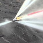 Hydrojetting nozzle spraying high-pressure water to clear sewer line clogs, illustrating effective plumbing services by The Plumbing Dr.