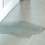Water leak on tiled floor indicating potential slab leak, relevant to plumbing repair services by The Plumbing Dr in Falls Church, VA.