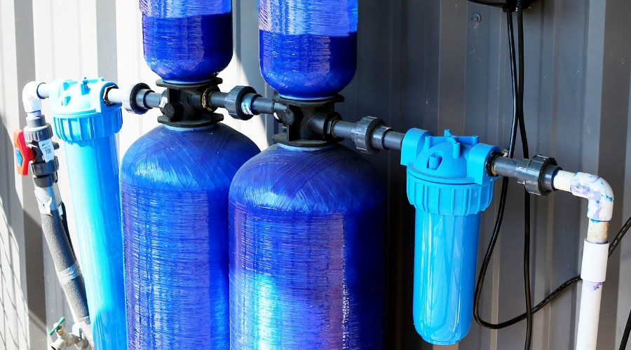 Water filtration system with blue tanks and plumbing components for clean drinking water installation.