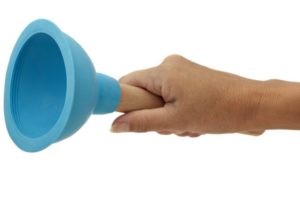 Hand holding a blue plunger, a common tool used for clearing blocked drains and plumbing emergencies.