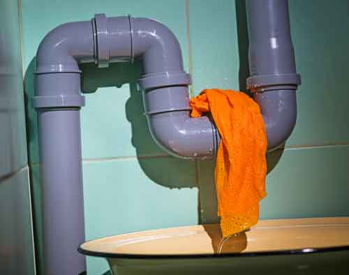 Pipe with orange cloth indicating a leak, emphasizing plumbing issues and leak detection in households.